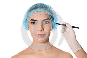 Doctor holding marker near young woman`s face isolated on white