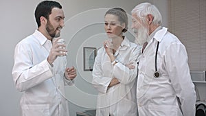 Doctor holding a medicine bottle and promoting to his collegues.