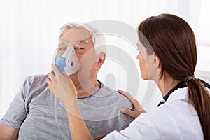 Doctor Holding Oxygen Mask Over Man`s Face