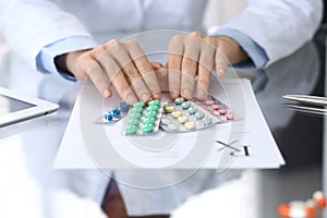 Doctor holding pack of different tablet blisters closeup. Life save service, legal drug store, prescribe medication