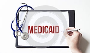 Doctor holding a paper plate with text MEDICAID, medical concept photo