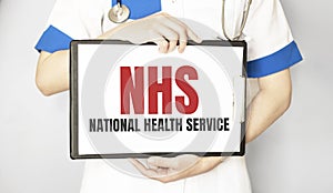 Doctor holding a paper plate with text NHS, medical concept photo