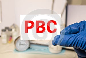 Doctor holding a paper plate with text PBC, medical concept