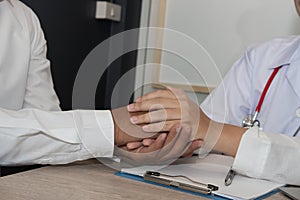 doctor holding patient hand & comforting him for bad news. physician support & encourage a man for medical examination. encourage