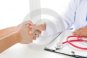 Doctor holding patient`s hand. Medicine and health care concept. photo