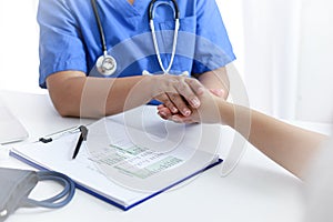 Doctor holding patient`s hand, and reassuring woman patient helping hand concept