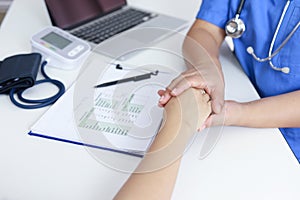 Doctor holding patient's hand, and reassuring woman patient helping hand concept