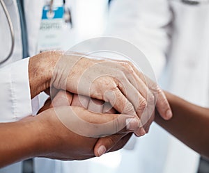 Doctor, holding a patients hands and comforting them after the loss of a loved one at a hospital. Medical consultant