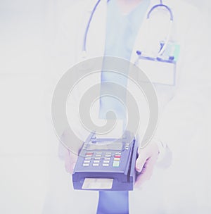 Doctor is holding payment terminal in hands. Paying for health care. Doctor