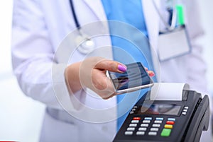 Doctor is holding payment terminal in hands. Paying for health care. Doctor