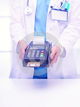 Doctor is holding payment terminal in hands. Paying for health care. Doctor