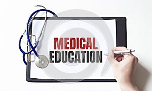 Doctor holding pen and paper plate with text MEDICAL EDUCATION, medical concept