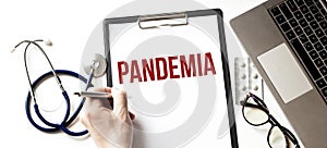 Doctor holding a pen and paper plate with text PANDEMIA, medical concept