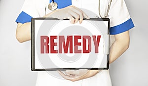 Doctor holding a pen and paper plate with text REMEDY, medical concept