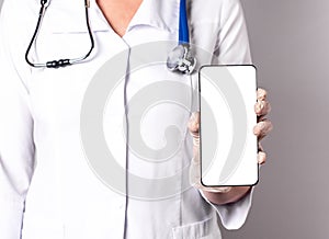 Doctor holding phone with screen mockup. Online medicine, using medical application in smartphone, telehealth