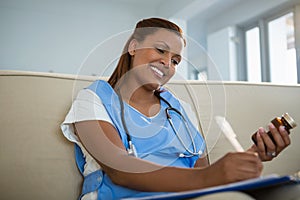 Doctor holding pills bottle and writing prescription