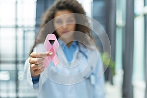 Doctor holding pink breast cancer awareness ribbon. Medicine and healthcare concept, women's health