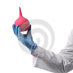 Doctor holding pink enema on white background