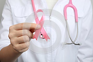 Doctor holding pink ribbon. Breast cancer awareness