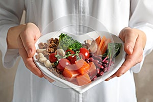 Doctor holding plate with products for heart-healthy diet