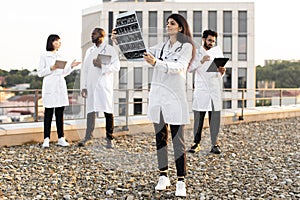 Doctor holding x-ray scan of patient during break outdoors hospital.