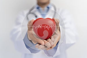 Doctor holding red heart shape in hand and modern medical network icon connected to virtual screen medical technology network