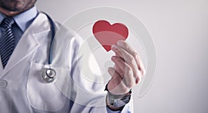 Doctor holding red paper heart. Healthcare and cardiology concept photo