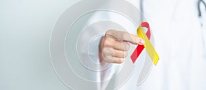 Doctor holding Red and Yellow ribbon. World hepatitis day awareness month, 28 July, Liver cancer, Jaundice, Cirrhosis, Failure,