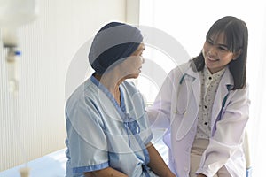 Doctor holding senior cancer patient`s hand in hospital, health care and medical concept