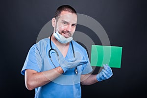 Doctor holding and showing green copypsace card photo