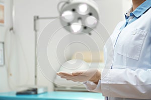 Doctor holding silicone implant for breast augmentation in clinic, closeup