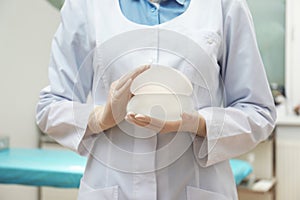 Doctor holding silicone implants for breast augmentation