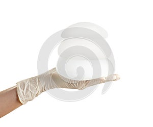 Doctor holding silicone implants for breast augmentation on white background.