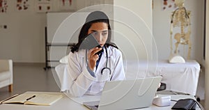 Doctor holding smart phone talking to patient using speakerphone