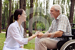 Doctor holding a smiling old man`s hand