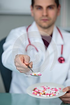 Doctor holding spoonful meds