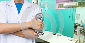 Doctor holding stethoscope with blurred hospital.