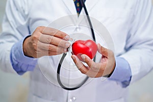 Doctor holding stethoscope and red heart in his hand in nursing hospital ward