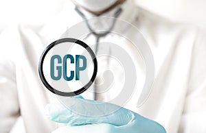 Doctor holding a stethoscope with text GCP, medical concept