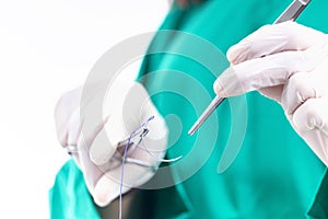 Doctor holding surgical forceps suture needle, suturing material