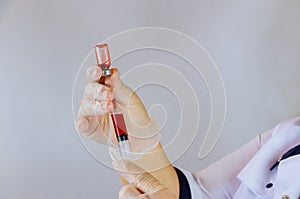 Doctor holding syringe dilution blood bottle at medical workplace