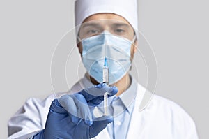 Doctor holding syringe with vaccine, ready for injection