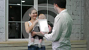 Doctor holding a tablet computer talking to mother and her child. White Display.