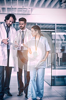 Doctor holding tablet while having discussion with colleagues