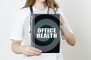 The doctor is holding a tablet with the inscription - Office Health