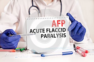 Doctor holding a tablet with text: AFP. AFP - Acute Flaccid Paralysis, medical concept photo