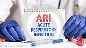 Doctor holding a tablet with text: ARI. ARI - Acute Respiratory Infection, medical concept