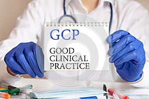 Doctor holding a tablet with text: gcp. gcp - good clinical practice, medical concept