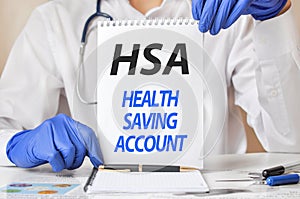 Doctor holding a tablet with text: HSA, medical concept