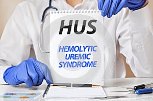 Doctor holding a tablet with text: HUS. HUS - Hemolytic Uremic Syndrome, medical concept